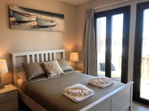 a bedroom with a bed with two towels on it at Noray Swan Duplex right at the Pool in Puerto Calero
