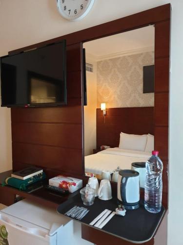 a hotel room with a bed and a clock on the wall at Mirage Al Salam Hotel in Medina