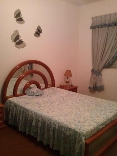 1 dormitorio con 1 cama y mariposas en la pared en Recanto do descanso, en Iguaba Grande