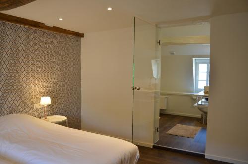 a bedroom with a bed and a bathroom at La Maurianne in Spa