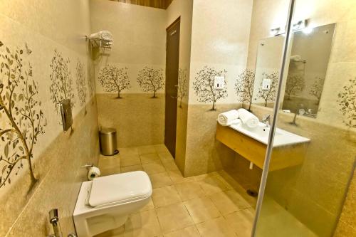 a bathroom with a toilet and a sink at Quartz Himalayan Brothers in Dharamshala