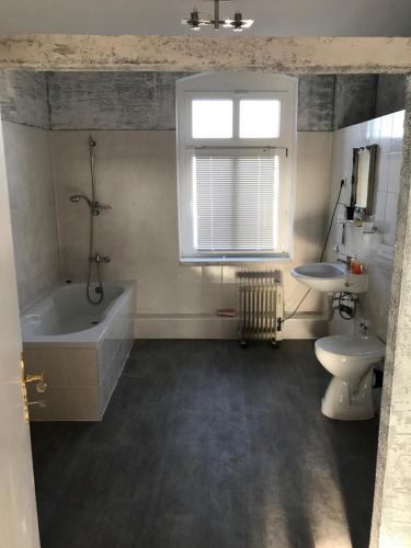 a bathroom with a tub and a toilet and a sink at Tränental in Staßfurt