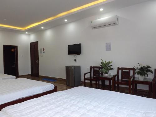 a hotel room with two beds and a flat screen tv at Lavender Hotel in Can Tho