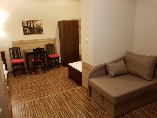 a living room with a couch and a table and chairs at Marcus in Bydgoszcz