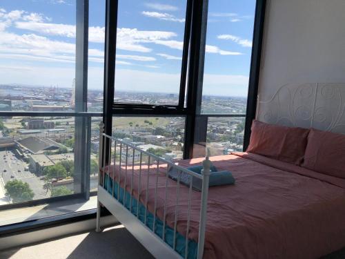 - une chambre avec un lit dans une pièce dotée de fenêtres dans l'établissement City Fringe Apt市中心的心灵港湾, à Melbourne