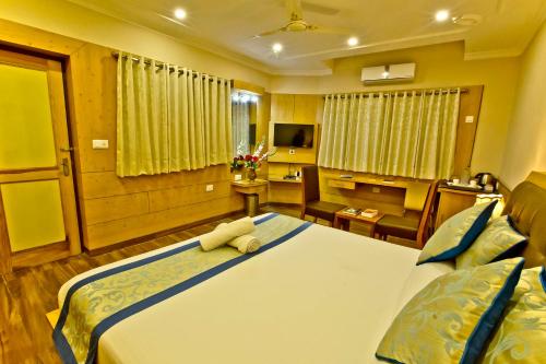 a bedroom with a large bed and a desk at Quartz Himalayan Brothers in Dharamshala