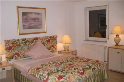 a bedroom with a bed with two tables and two lamps at Hotel Krone in Sindelfingen