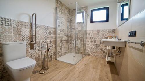 a bathroom with a shower and a toilet and a sink at Apartamentos Rurales Argame in Argamé