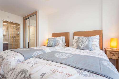 two twin beds in a bedroom with a window at Treetops Apartment in Milton Keynes