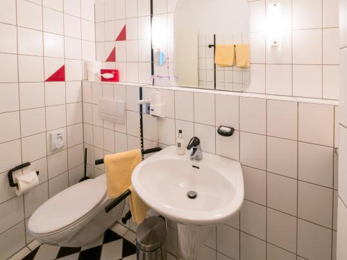 a white bathroom with a sink and a toilet at Hotel Löwen Garni - B&B in Rust