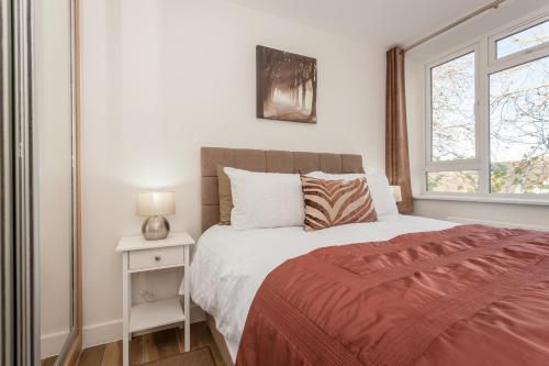 Un dormitorio con una cama grande y una ventana en Treetops Apartment en Milton Keynes