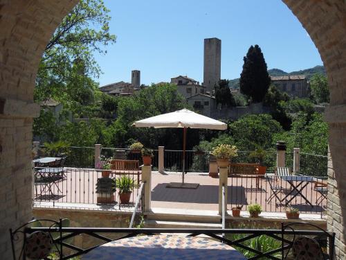 an archway with an umbrella and tables and chairs at Antico Borgo Piceno in Ascoli Piceno