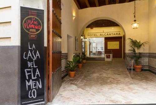 a large building with a sign on the side of it at Hotel Alcántara in Seville