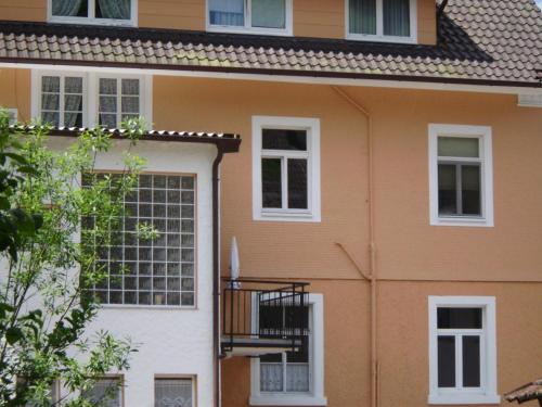 a orange and white house with a balcony at Finken, Gästezimmer an der Rench in Oppenau
