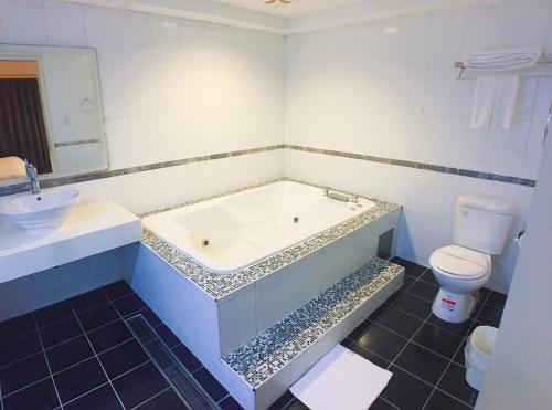 uma casa de banho com uma banheira, um WC e um lavatório. em Love Hotel em Taipei
