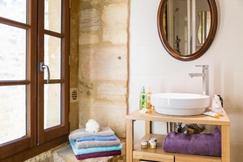 a bathroom with a sink and a mirror at Au coeur de Beynac, superbe maison du 16ème siècle avec jardin panoramique in Beynac-et-Cazenac