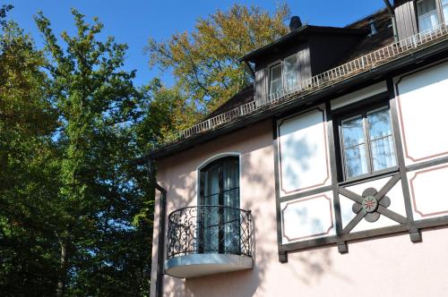 a building with windows and a balcony and trees at relexa hotel Schatten Stuttgart in Stuttgart