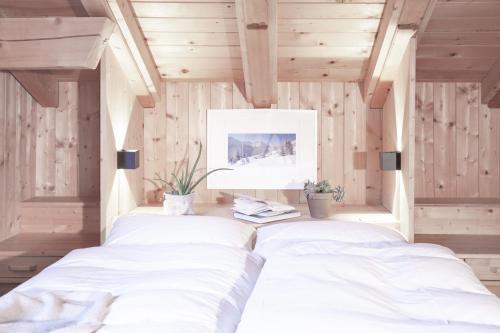 two beds in a room with wooden walls at Club Nordic in Sankt Anton am Arlberg