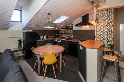 uma cozinha com uma mesa de madeira e uma cadeira amarela em 6 Rue d'Aubuisson em Toulouse
