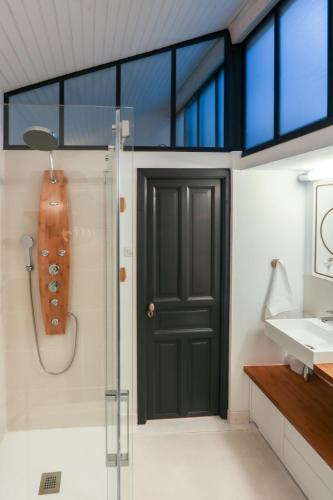 La salle de bains est pourvue d'une douche et d'une porte noire. dans l'établissement 6 Rue d'Aubuisson, à Toulouse