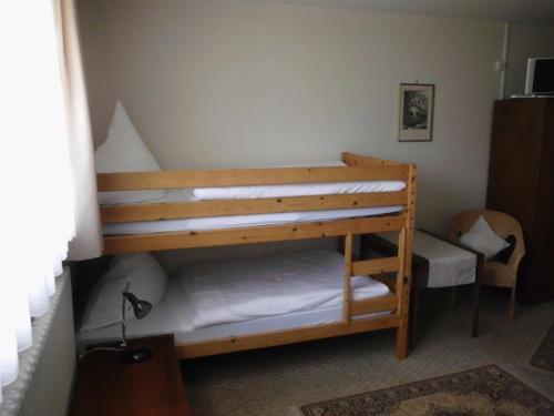 a bedroom with two bunk beds and a chair at Finken, Gästezimmer an der Rench in Oppenau