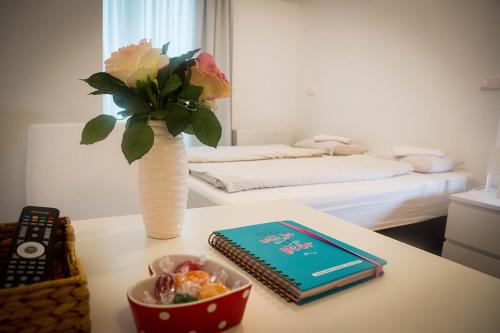a vase with a bouquet of flowers and a book on a table at Hauptbahnhof S2 in Vienna