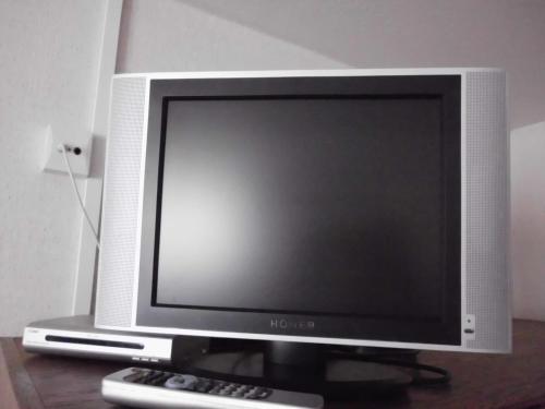 a computer monitor sitting on a table with a remote control at Finken, Gästezimmer an der Rench in Oppenau