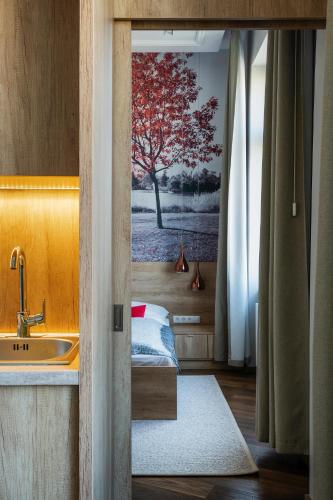 a bathroom with a sink and a tree painting on the wall at Lakeside Budapest Residences 1 MIN FROM METRO in Budapest