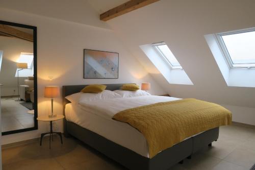 a bedroom with a bed with yellow sheets and windows at Zurich Furnished Homes in Zürich