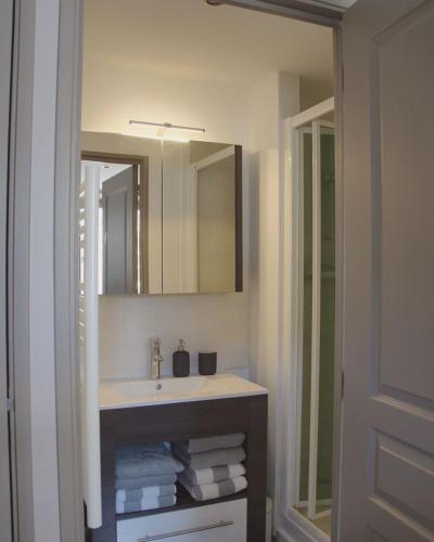 une salle de bain avec un lavabo et un miroir dans l'établissement Corps de ferme restauré proche Barbizon, à Saint-Martin-en-Bière