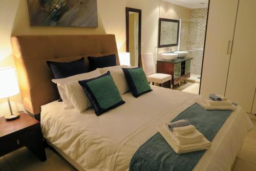 a bedroom with a large white bed with green pillows at Sea-View Nautica @ Mossel Bay in Mossel Bay