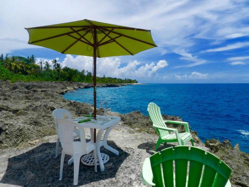two chairs and a table with an umbrella on the beach at Ocean View Sai in San Andrés