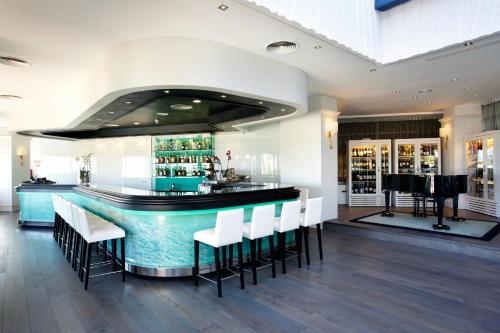 a bar with white chairs and a blue counter at GPRO Valparaiso Palace & Spa in Palma de Mallorca