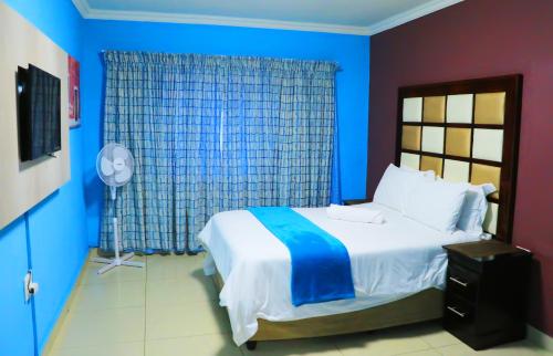 a bedroom with a large bed with blue walls at Angel Guest House in Johannesburg
