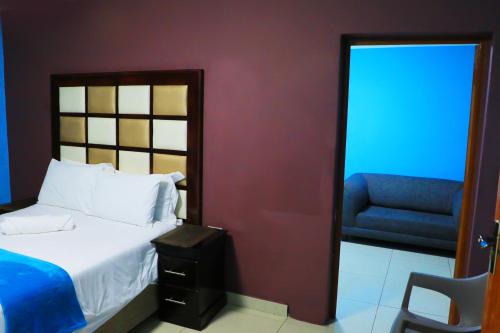 a bedroom with a bed and a chair and a window at Angel Guest House in Johannesburg