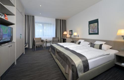 a hotel room with a large bed and a television at Hotel Spiegel in Cologne
