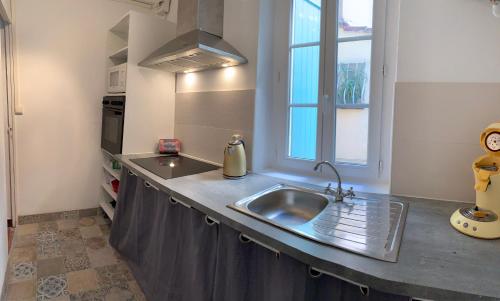 a kitchen with a stainless steel sink and a window at Studio Calendal in Cassis