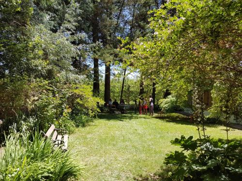 a park with people sitting on benches and trees at Casa de Campo Flor Dorada in Centenario