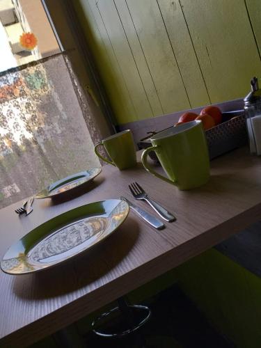 a wooden table with plates and utensils on it at modern Hoteliving Gießen in Gießen