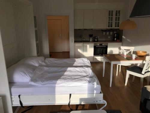 a bedroom with a bed and a table and a kitchen at Central Garden-Mountain Apartment in Garmisch-Partenkirchen