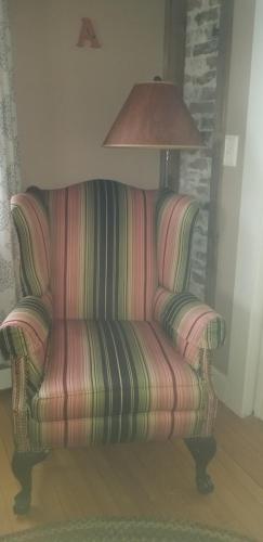 a striped couch in a living room with a lamp at Hallowell Rooming House in Hallowell