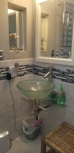 a bathroom with a glass sink and a mirror at Hallowell Rooming House in Hallowell