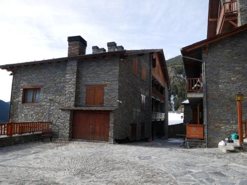 a large stone building with a wooden door at Ransol - El Tarter in Ransol