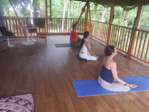 tres mujeres sentadas en el suelo en una clase de yoga en Cabaña El Bien Germina Ya, en El Valle