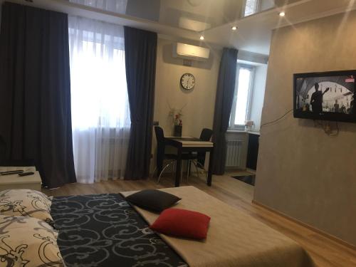 a bedroom with a bed and a desk and a television at Квартира-Студия в Центре in Vinnytsya