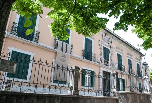 リスボンにあるPretty Viewsの緑の扉と柵のピンクの建物