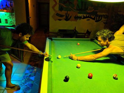 two men playing a game of sn pool at Divanga Hostel and Diving in Taganga
