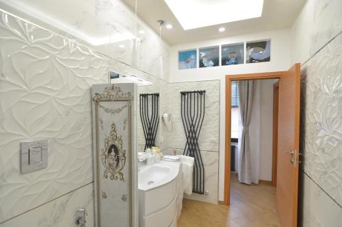 a white bathroom with a sink and a tub at Caserta Deluxe in Caserta