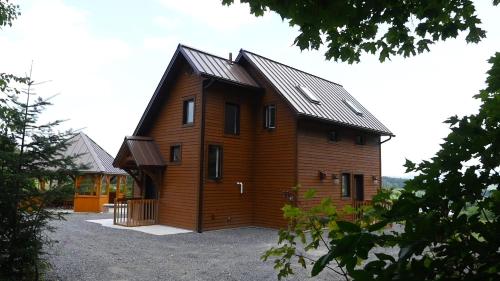 a large wooden cabin with a gambrel roof at Domaine Gagnon in Saint Sebastien