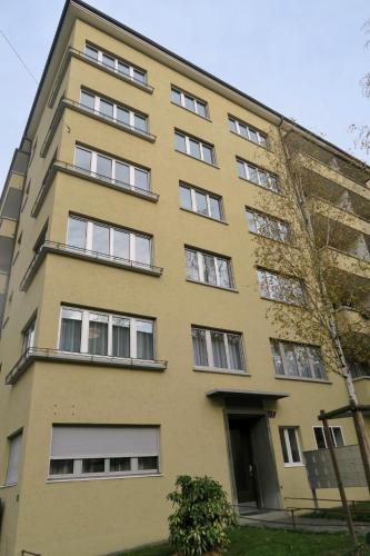 a tall yellow building with many windows at Zurich Furnished Homes in Zürich